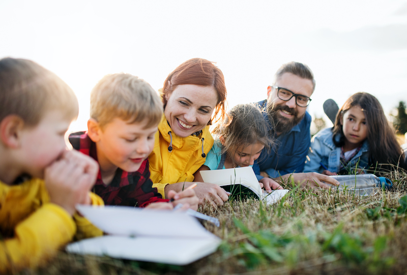 Group of school children with teacher on field trip in nature.