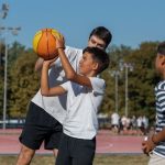 boys participates in an outdoor basketball