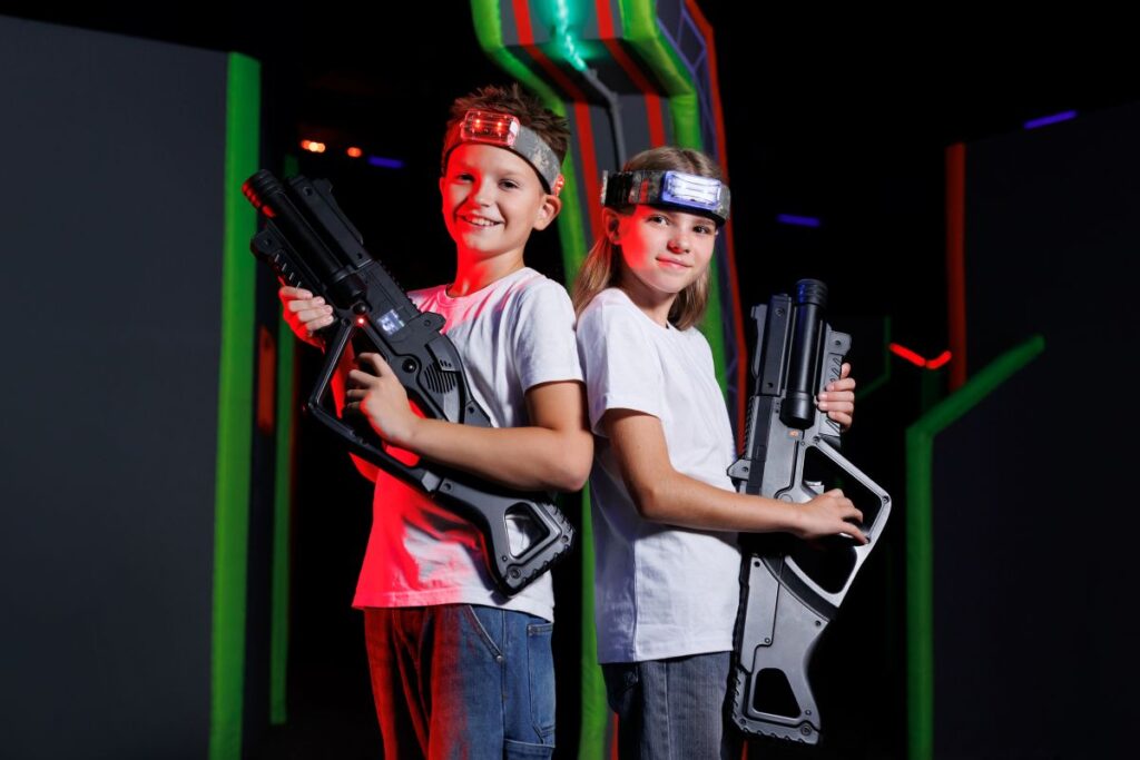 smiling boy and girl holding laser tag guns